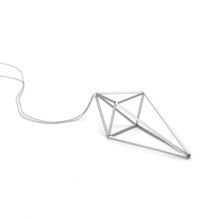 Anhänger groß, silberfarben Silberfarbener Anhänger an grauer Seidenschnur. Der Anhänger prisma beschreibt einen ungleichseitigen Doppeltetraeder, der an Kristall erinnert. Er ist aus eloxierten Aluminiumröhrchen, die unsichtbar auf Nylon aufgezogen die Seitenkanten des Polyeders bilden.