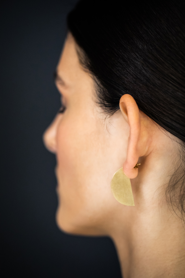 ohrstecker-moon-golden Frauenkopf im Profil mit vergoldetem Ohrstecker. Dieser beschreibt eine Halbkreisscheibe, 30mm im Durchmesser. Der Ohrschmuck ist so getragen, dass der Halbkreis im Profil, also von der Seite zu sehen ist.