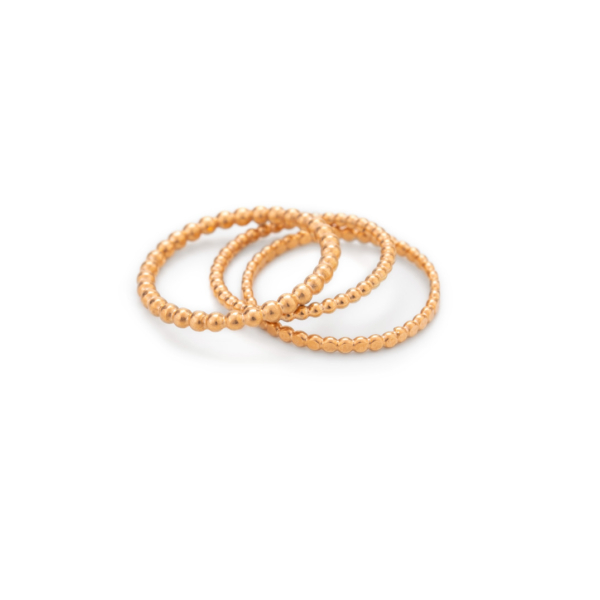Drei Ringe aus unterschiedlich großen Kügelchen liegen aufeinander, leicht aufgefächert. Die Kügelchen der Ringe haben unterschiedlich große Durchmesser von 1,5mm bis 2mm. Alle sind sie aus Sterlingsilber gearbeitet und rosé gold plattiert.