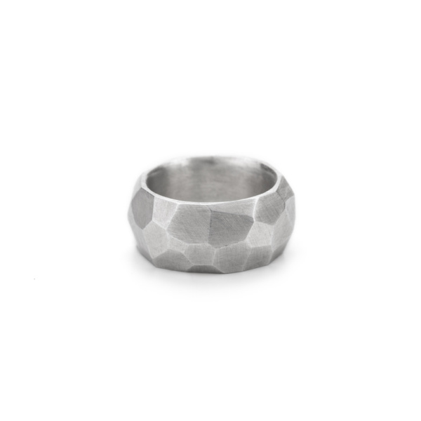 Sehr breiter und dicker Ring aus Sterlingsilber. Die Oberfläche ist mit zahlreichen ungleichmäßigen Facetten versehen, die eine interessante Erscheinung von Licht und Schatten ergeben.