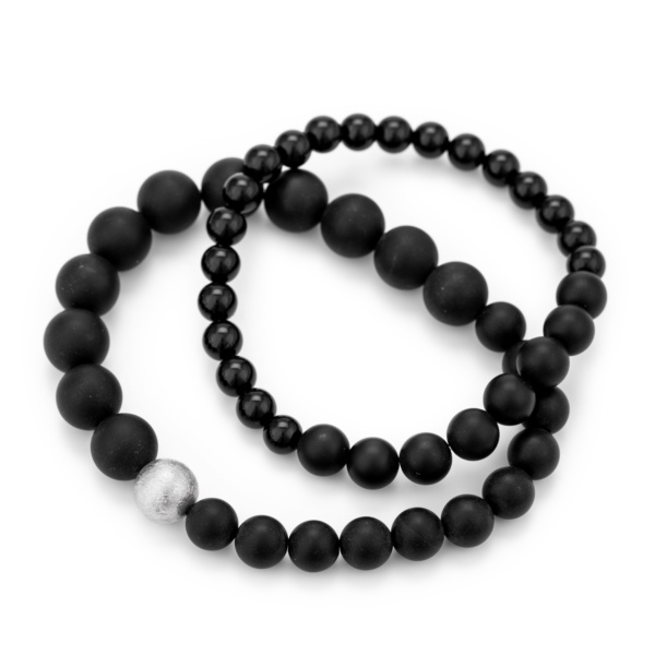 Bracelets made of different sized onyx beads strung on sturdy silicone cord. One bracelet has a silver ball strung on it.