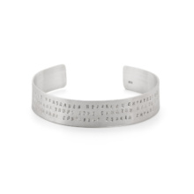 armreif-text-silber Breiter Bandarmreif aus Silber mit drei Zeilen Wörtern punziert.