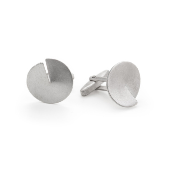 Circular sterling silver cufflinks with familiar cufflink mechanism on the reverse. The decorative plate is cut to its centre and the resulting slit is slightly bent upwards to create a spatial effect.