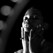 3ringe_globulus Eine Frau lässt ihr Gesicht in ihren Händen ruhen, die Hände sind mit drei Ringen aus geschwärztem Silber geschmückt besetzt mit jeweils einer geschwärzten Silberkugel und einer Steinkugel aus Rauchquarz, Onyx matt und Onyx glänzend.