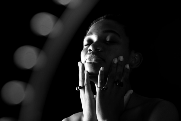 3ringe_globulus Eine Frau lässt ihr Gesicht in ihren Händen ruhen, die Hände sind mit drei Ringen aus geschwärztem Silber geschmückt besetzt mit jeweils einer geschwärzten Silberkugel und einer Steinkugel aus Rauchquarz, Onyx matt und Onyx glänzend.