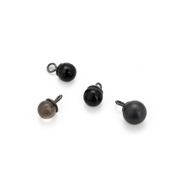 anhaenger_globulus_variation Vier kugelförmige Kettenanhänger aus unterschiedlichen Materialien: Rauchquarz, Onyx und Silber, mit einer geschwärzten Silberöse.