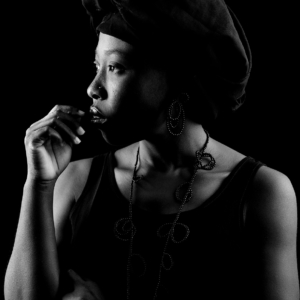 Frau mit Kette und Ohrschmuck aus kleinen Onyxperlen. Die Perlen sind zu unterschiedlich großen Schlaufen, ähnlich wie Blätter, auf Nylon aufgezogen.