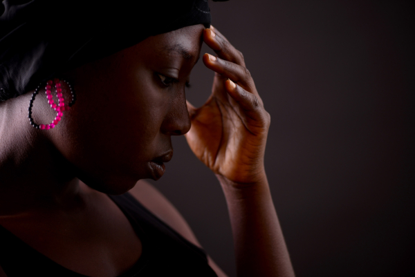 ohrschmuck_tendril_pink Frau im Profil mit Ohrschmuck aus kleinen Onyx- und Karneolperlen. Die Perlen sind zu zwei sich überschneidenden Schlaufen auf Nylon geknüpft.