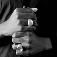 ring_connected_konvex+konkavrund Männerhände, die zwei fette Siegelringe mit aus Silber tragen. Beide Siegelplatten sind kreisrund. Die eine konvex, die andere konkav gewölbt, so dass sie auch ineinander passen.