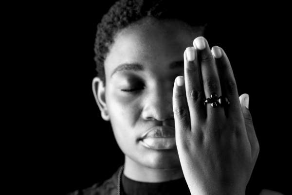 ring_globuli Eine Frau hebt ihre Hand vor ihr Gesicht. An dieser trägt sie einen schwarzen Silberring mit unterschiedlich großen Kugeln verziert, aus Onyx und Hämatit.