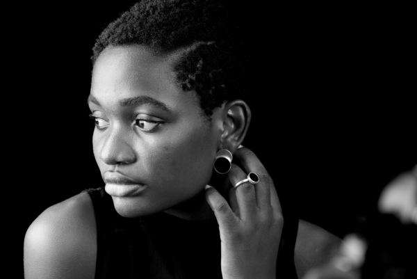 ring_laminam_onyx2 Eine Frau trägt Ohrstecker und einen Ring aus Silber, verziert mit runden Onyxsteinen.