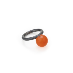 Schlichter Ring aus geschwärztem Silber mit einer 12mm großen, orangenen Karneolkugel verziert.