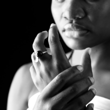 ringe_globulus Nahaufnahme einer Frau, die zwei Ringe aus Sterlingsilber trägt. Einer mit einer Silberschale und einer Onyxkugel, der andere mit einer Silber- und einer facettierten Onyxkugel.