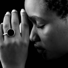 ring+ohrst_laminam1_.onyxjpg Nahaufnahme einer Frauenhand mit einem Silberring mit 18mm großer Onyxscheibe