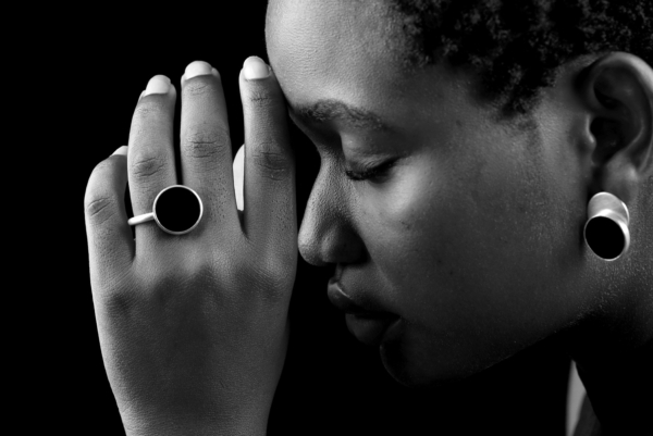 Close-up of a woman's hand wearing a silver ring with an 18mm large onyx disc.