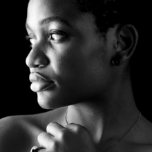 schmuckset_globulus Nahaufnahme einer Frau, die eine Kette und einen Ring aus geschwärztem Silber mit Onyxkugel trägt.